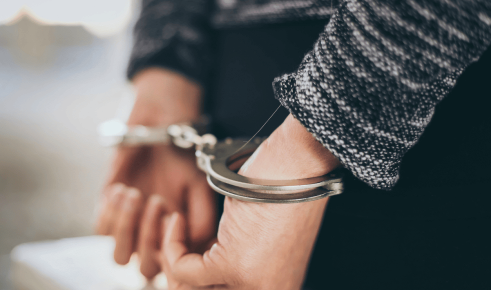 Close-up of a person’s hands in handcuffs, symbolizing an arrest. The image supports a legal blog explaining that bail in Houston, Texas applies to a wide range of offenses, including misdemeanors and non-violent felonies, and how individuals can secure a bond through the proper legal process.