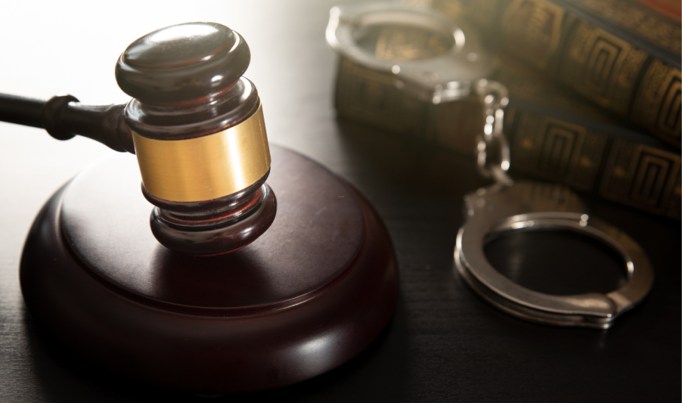 Judge's gavel beside handcuffs and law books, symbolizing the misdemeanor bail bond process and the legal steps to secure release after an arrest in Houston.